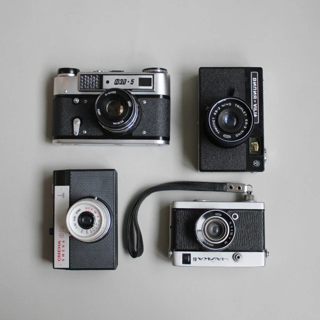 two old fashioned cameras laying next to each other