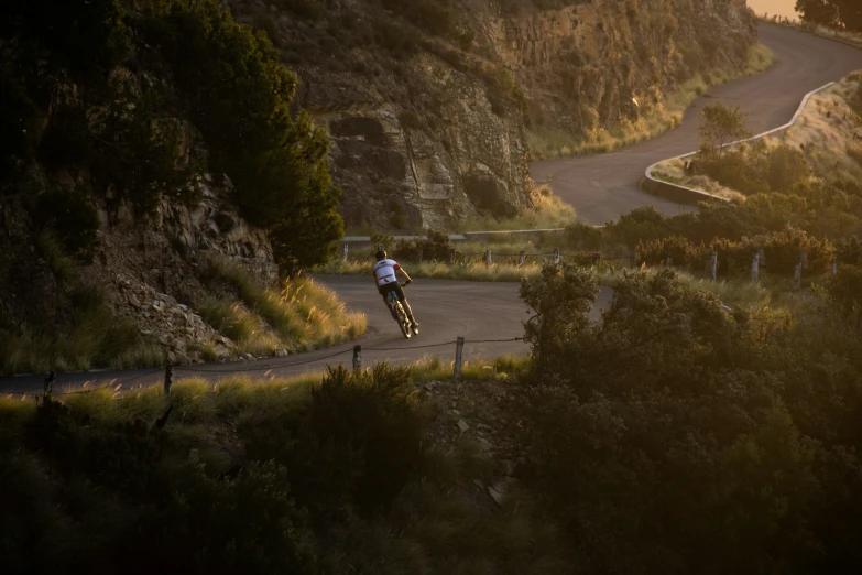 a man riding his bike down a mountain