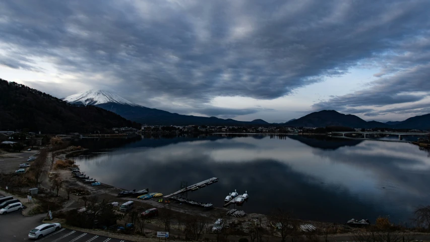 a lake sits surrounded by mountains and cars