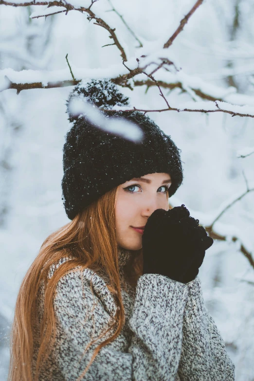 a woman with red hair wearing a knitted hat