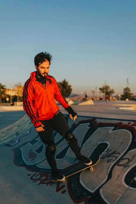 the skateboarder is wearing red and his jacket is black