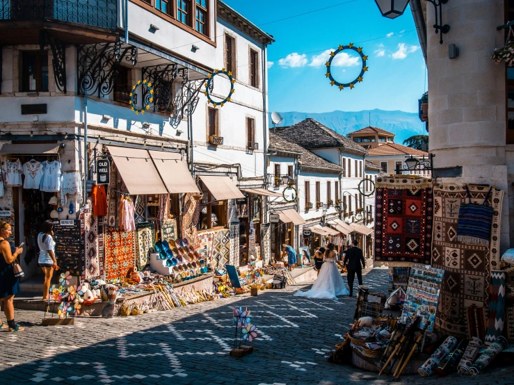 a street with shoppers and people looking at merchandise in a market