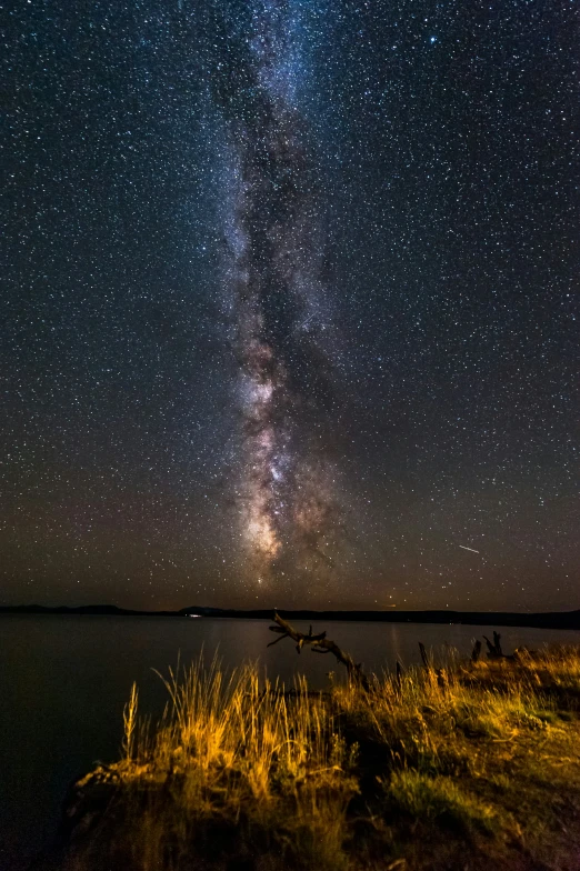 the night sky with stars over a body of water