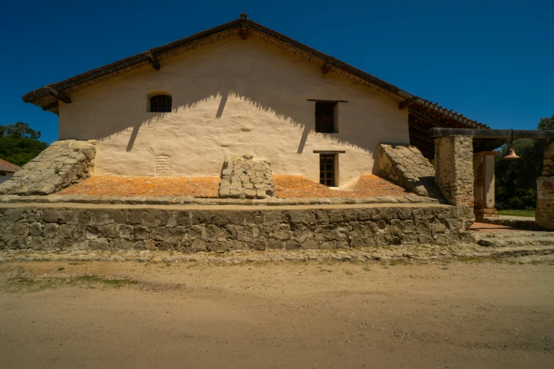 an adobe - style building surrounded by a rocky barrier