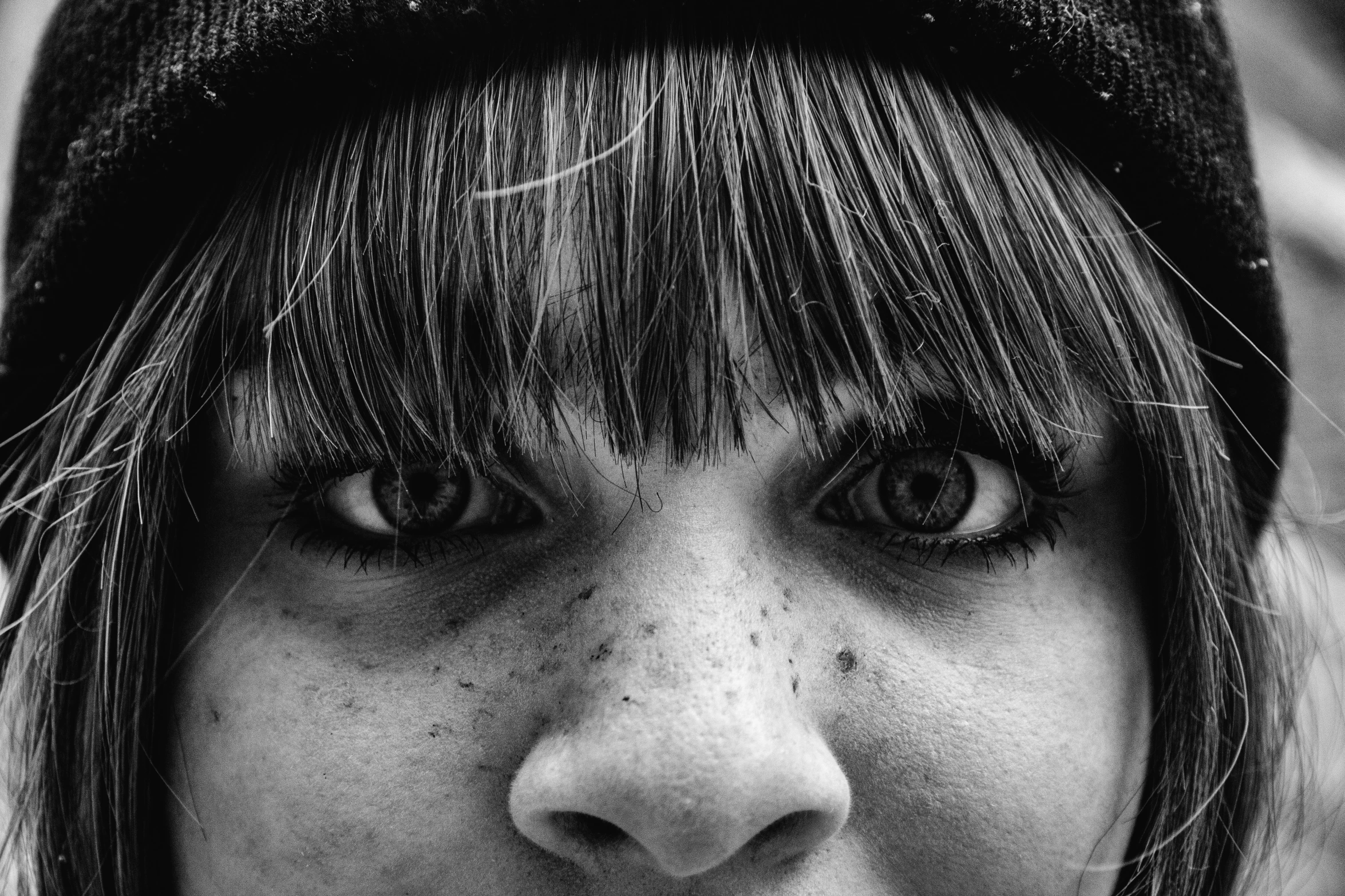 a black and white po of a young woman with a hat on her head