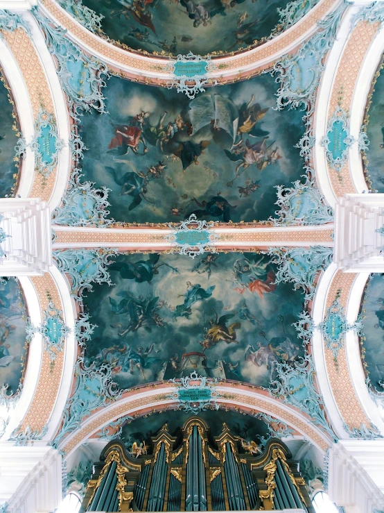 ornate wallpaper decorates a painted ceiling in a church