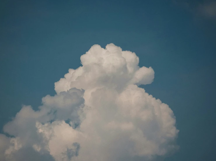 an airplane flying high up in the air on a sunny day