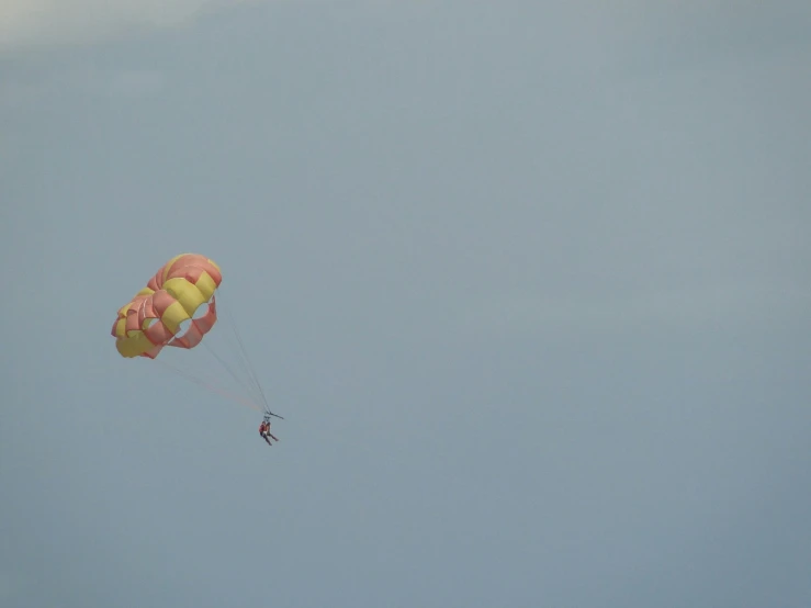 a person on a parachute with two large balloons