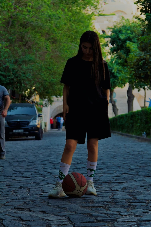 a woman with her foot on the ground near a ball