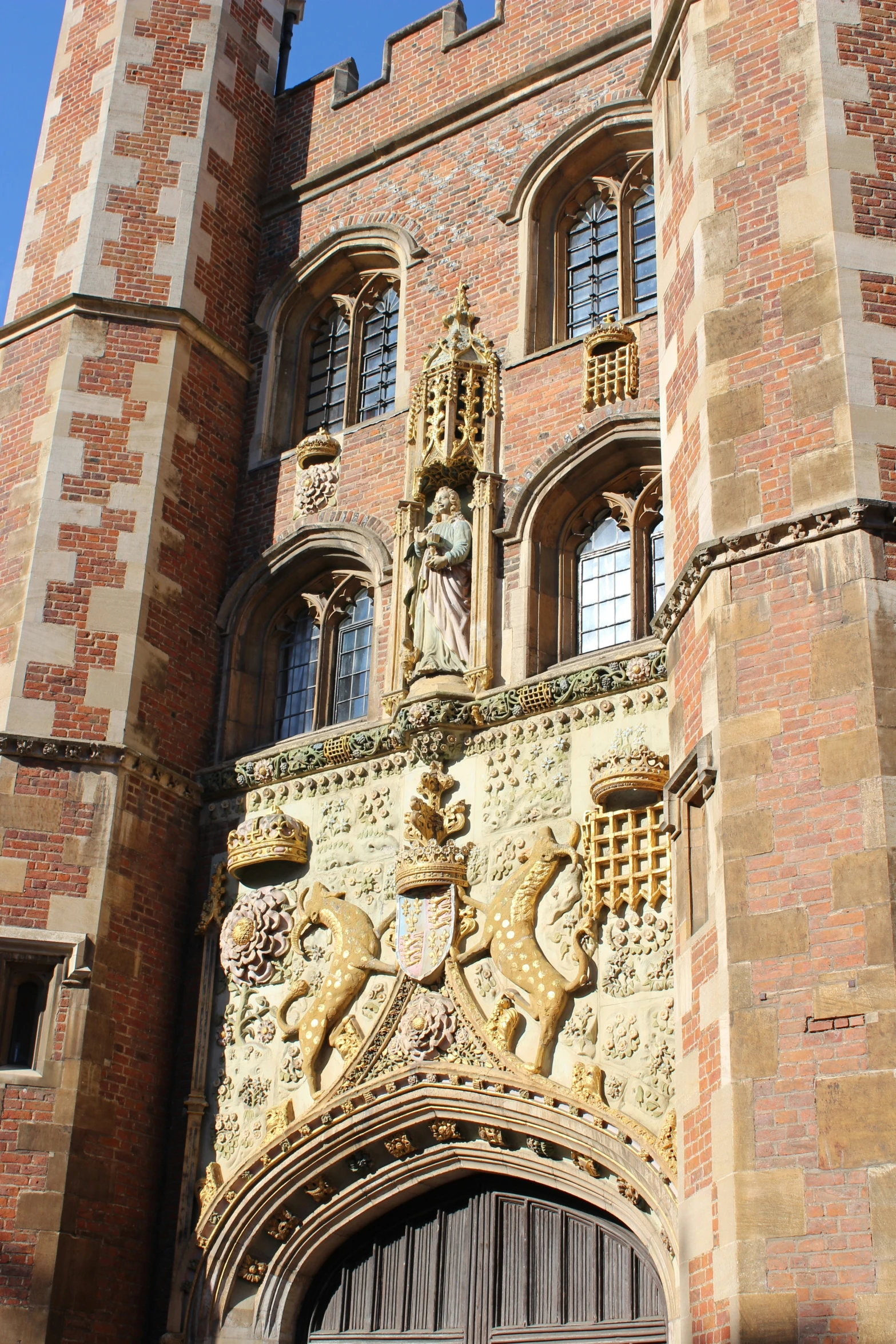 a large brick building with a clock and statues