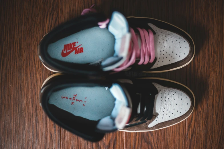 three sneakers are laying on top of a wooden table