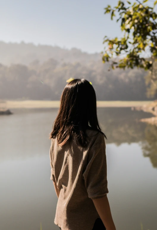 a girl standing in front of a body of water