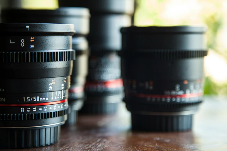 four camera lenses stacked up together on a table