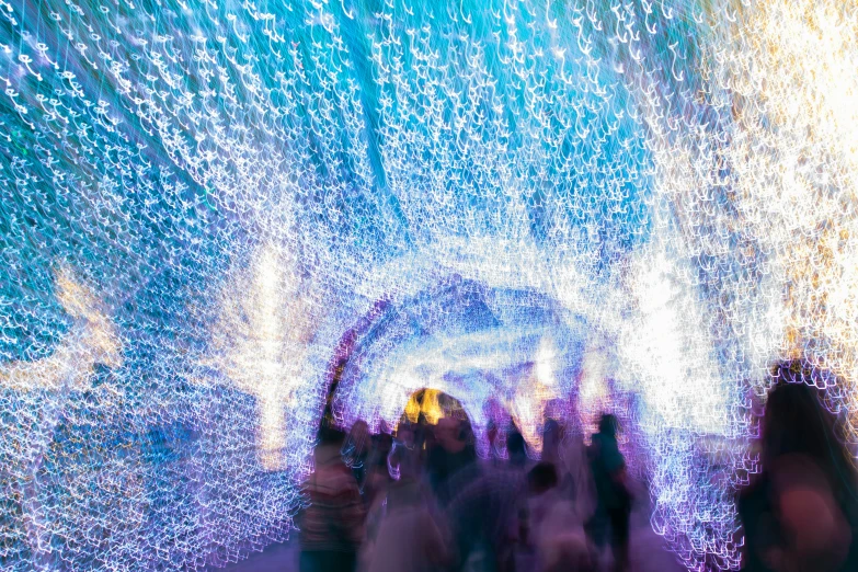 a group of people walking through a tunnel covered in rain drops