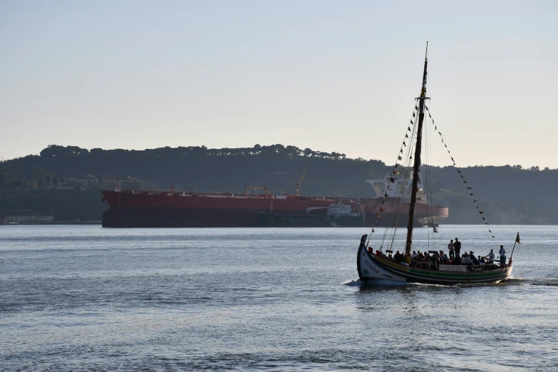 a large ship sailing in the ocean with a boat on it's back