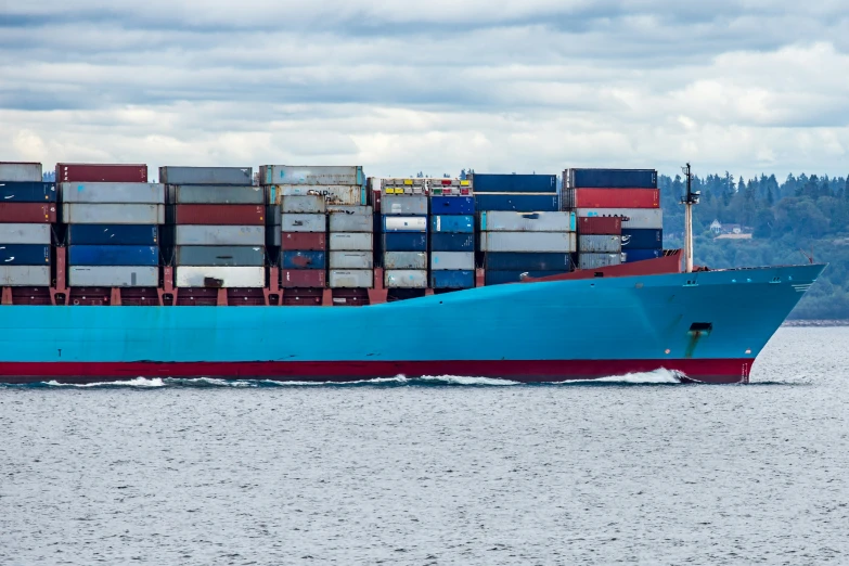 a large blue boat is traveling by the water