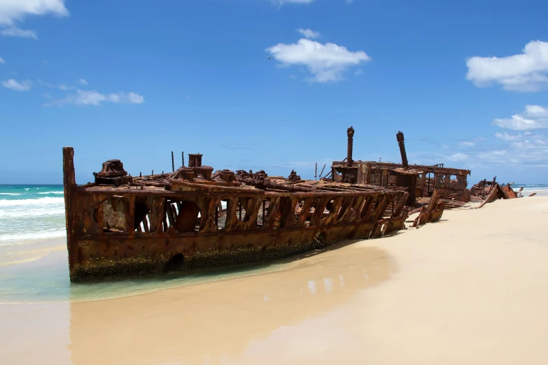 an old rusted out ship on a beach