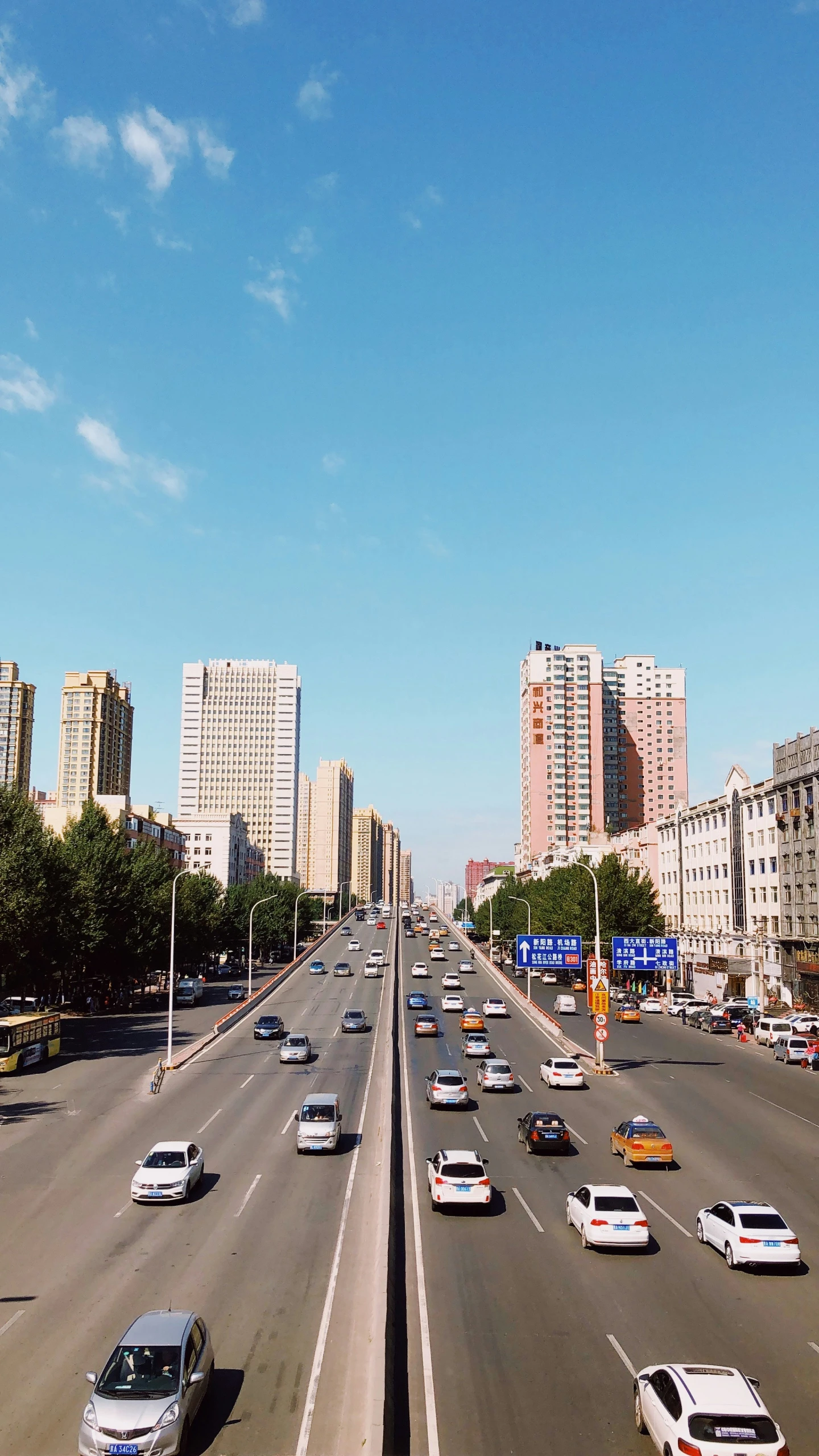 a number of cars on a road near tall buildings