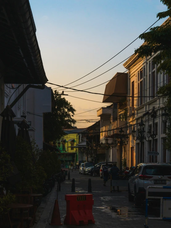 some people buildings cars and street lights at dusk