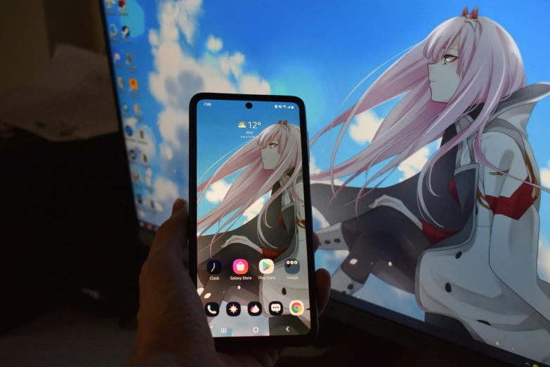 someone holding up a phone displaying the anime scene