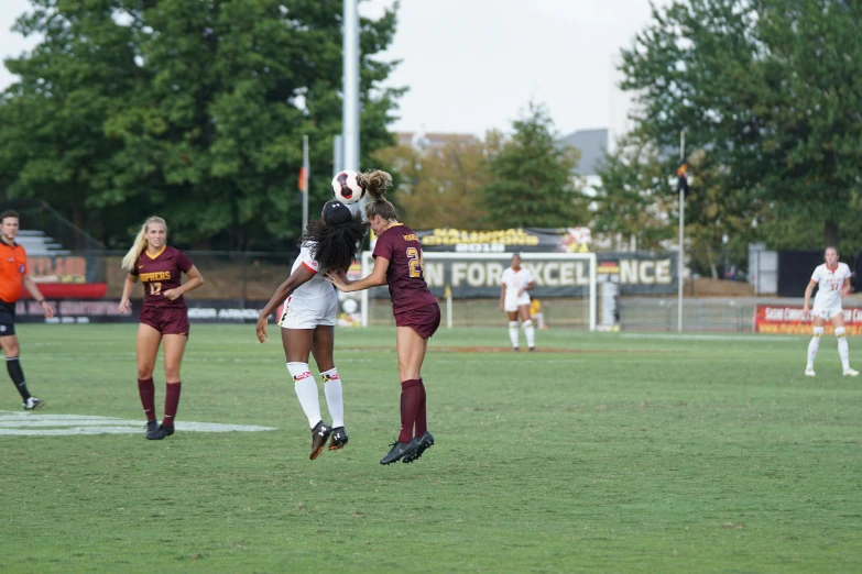 two women are playing soccer on a field