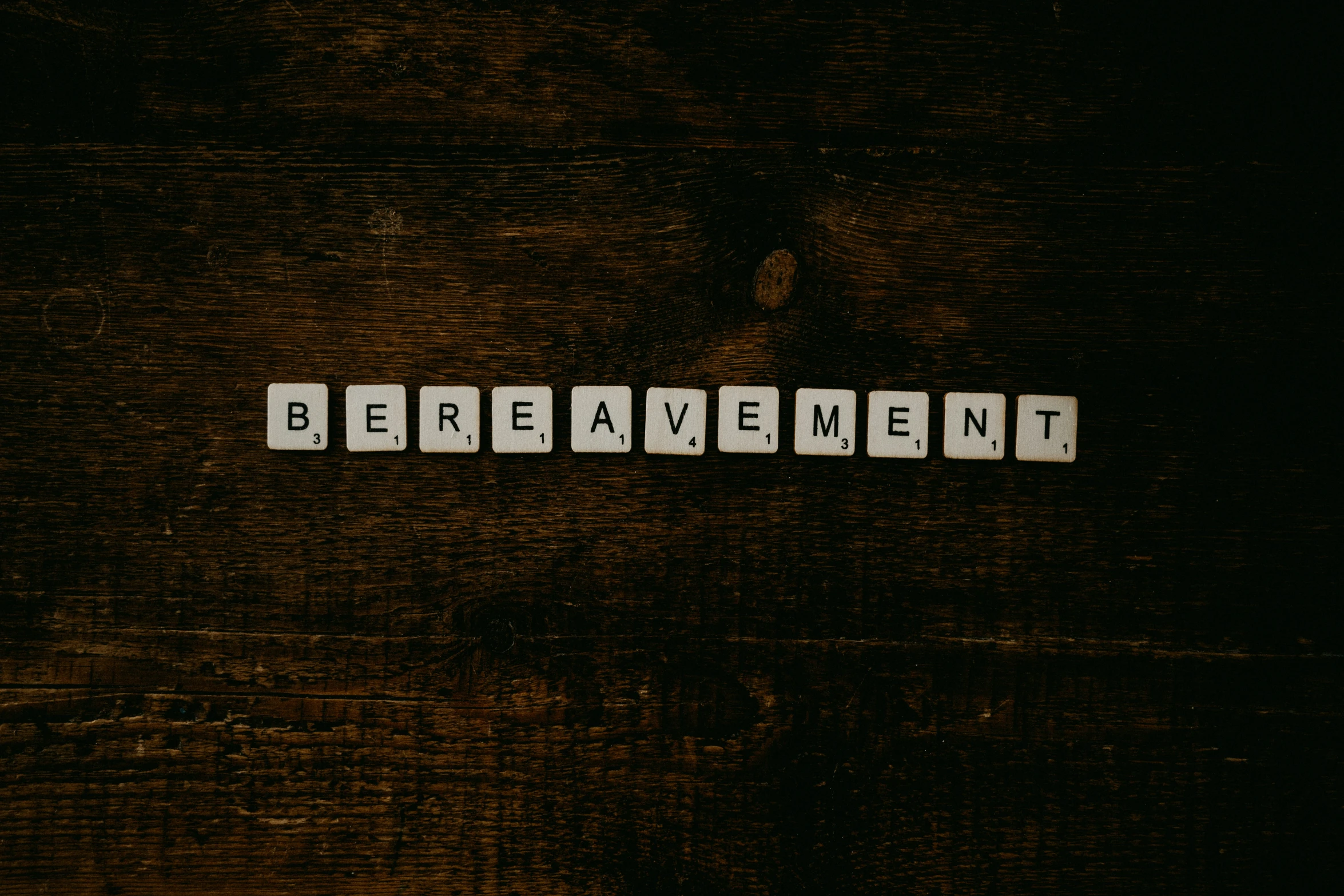 a close up of a scrabble type word with the word bereavement on it