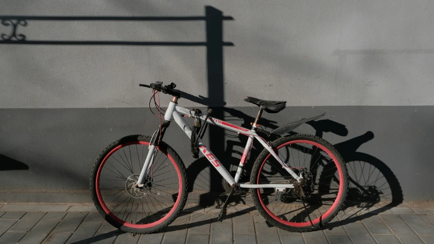 a bike leaning up against a wall with a shadow