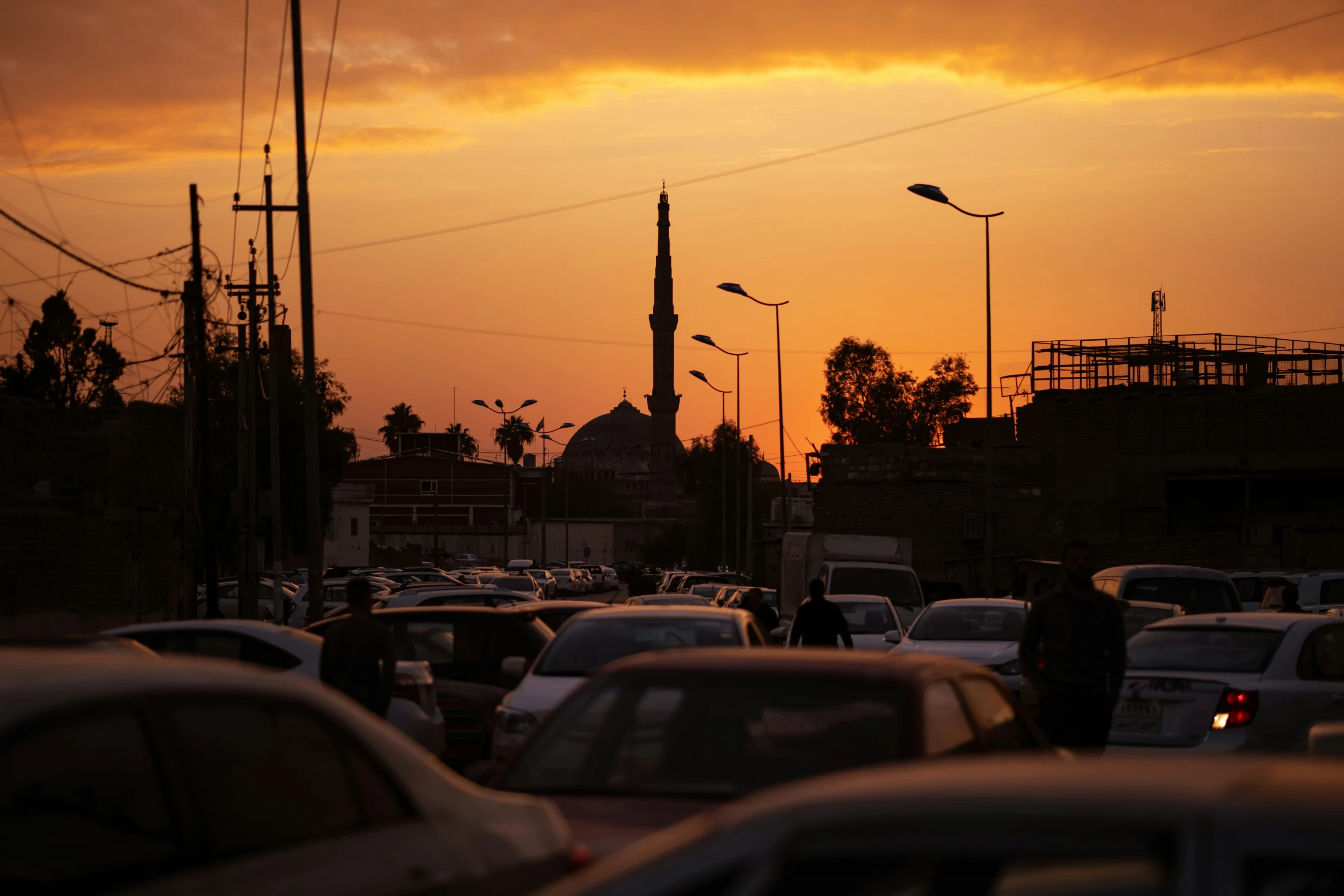 cars are parked on the street during sunset