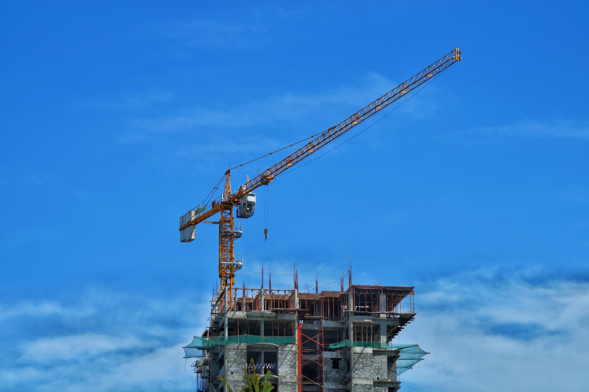 a crane is setting on the top of a tall building