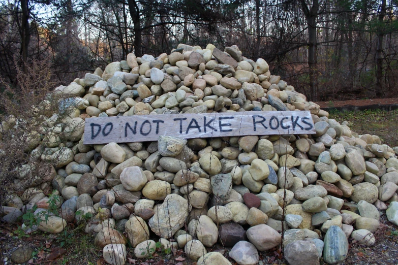 rocks with writing and a do not take rocks sign