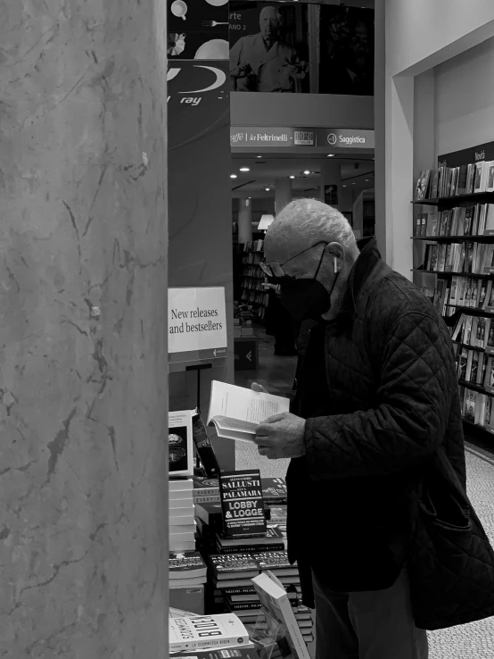 man talking on the phone with books behind him in a bookstore