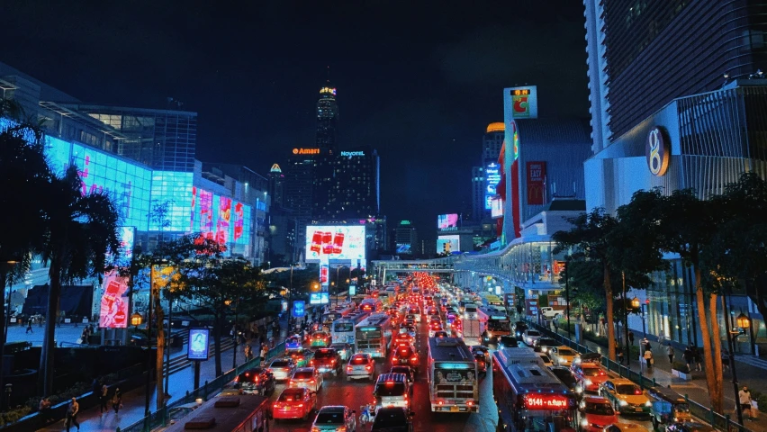 city street with cars and billboards at night