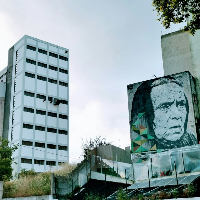 a large image of a man is painted on a building in the city