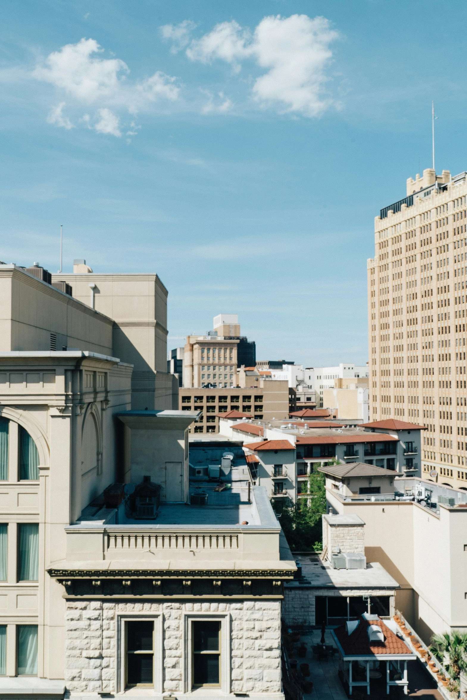 a very tall white building next to some very tall buildings