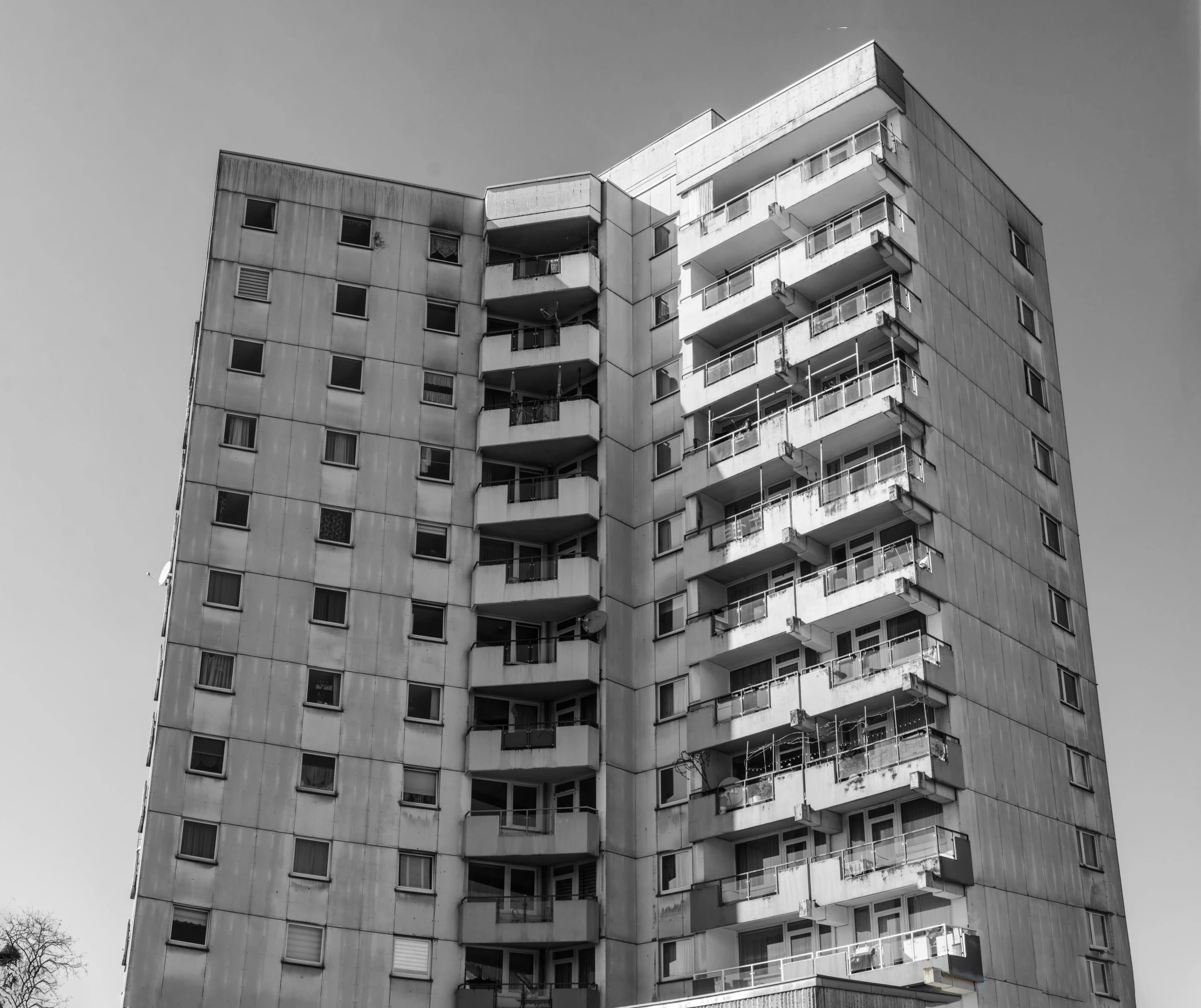 two buildings with balconies on them and an orange street sign in front