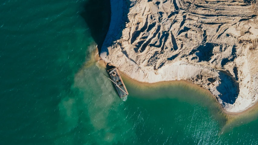 an aerial s of the ocean with a boat in it