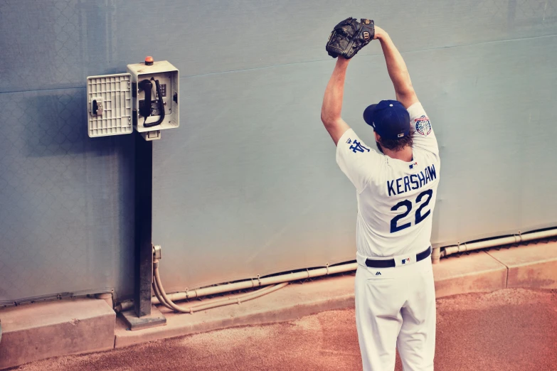 the baseball player is holding up his glove