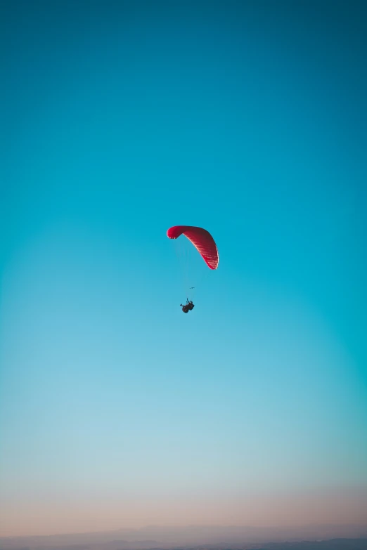 a man is para sailing on a clear blue sky