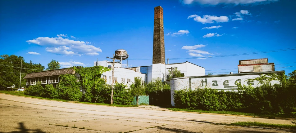 an old industrial building sits beside the road