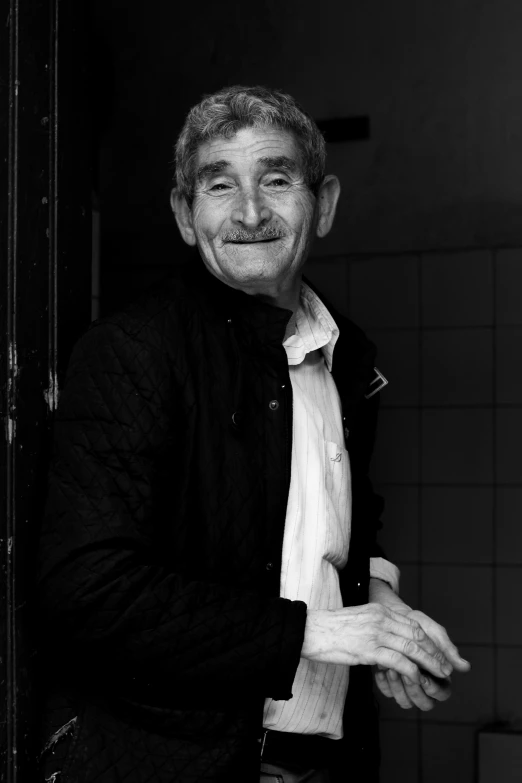 man in shirt and tie smiling with hands folded over mouth