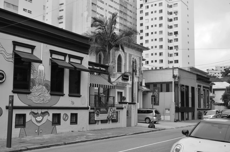 a small car drives down a street with many buildings on either side