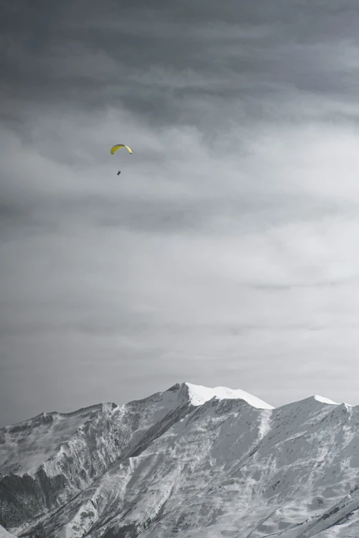 a para sailor flies near a snowy mountain range