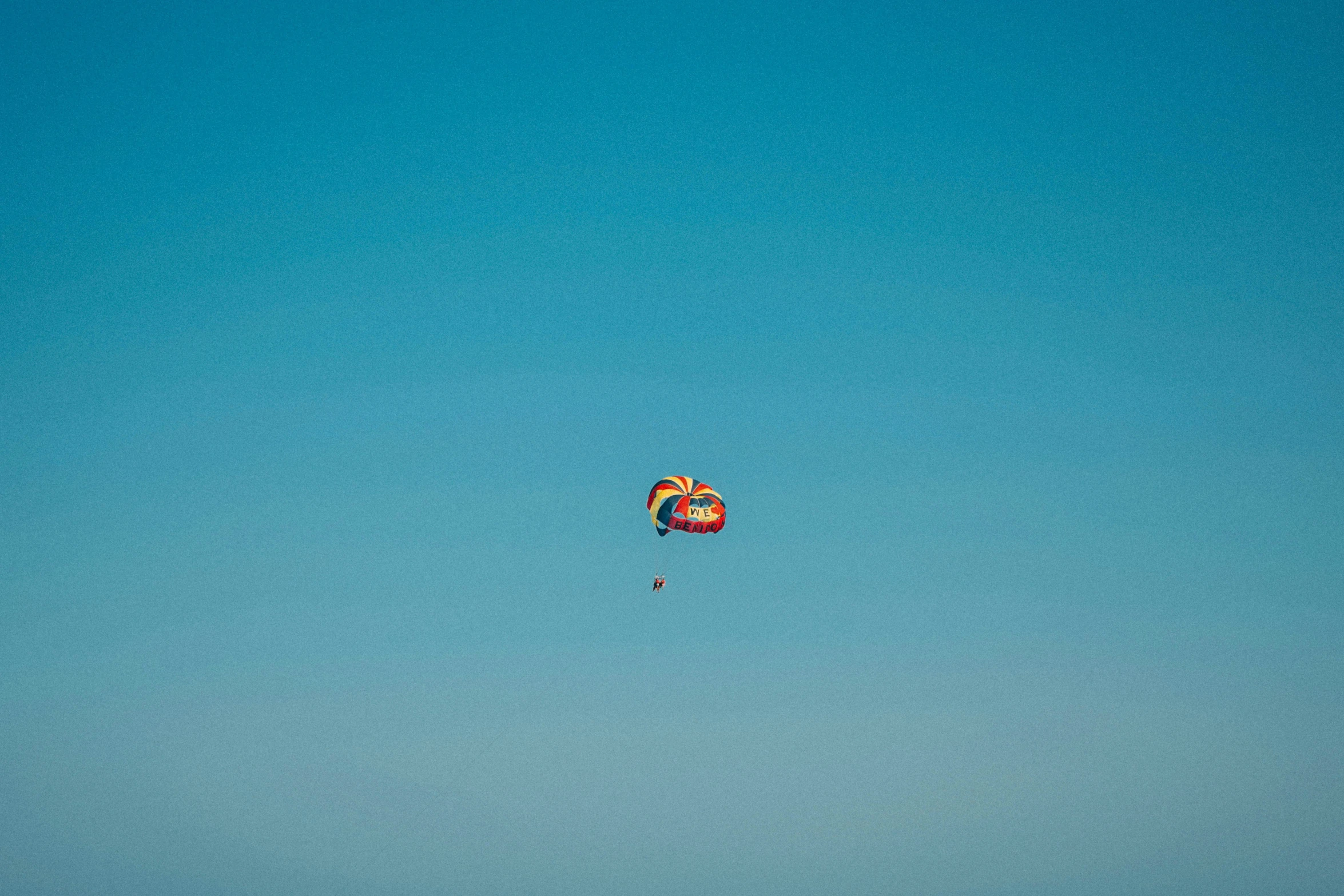 a colorful, flying bird kite can be seen in the sky