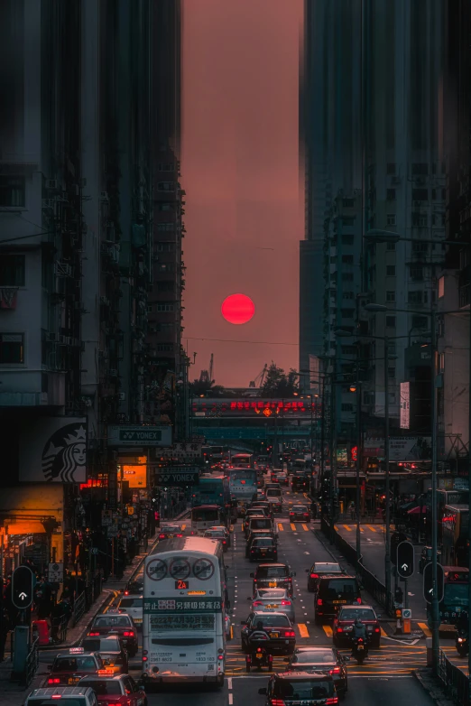 a city intersection with many cars, some in traffic and a red ball in the background