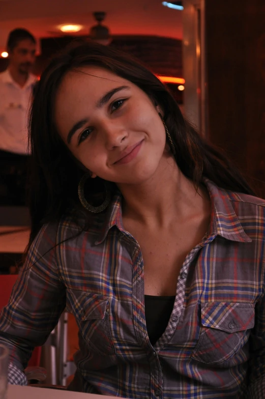 a woman sits at a table smiling for the camera