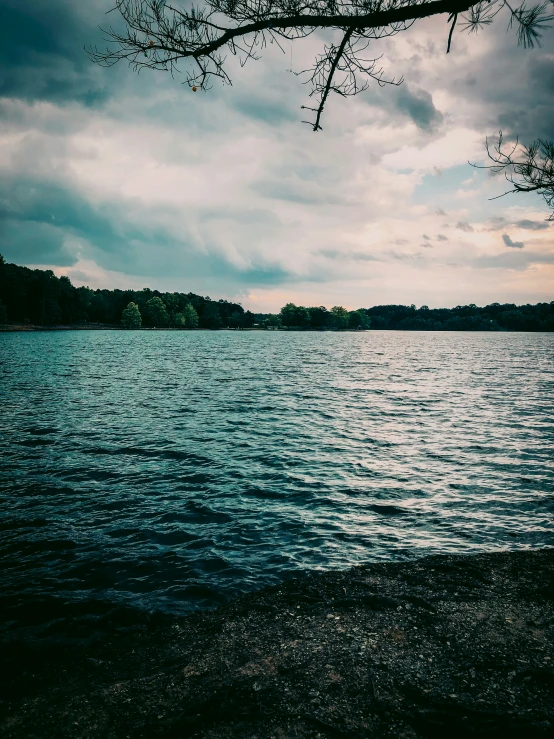 a black and white pograph of the ocean on a cloudy day