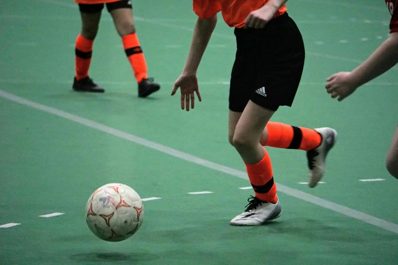 three s kicking around a soccer ball while playing