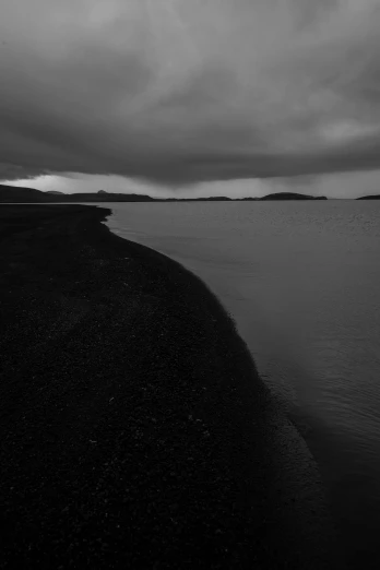 a large body of water sitting under a gray cloudy sky