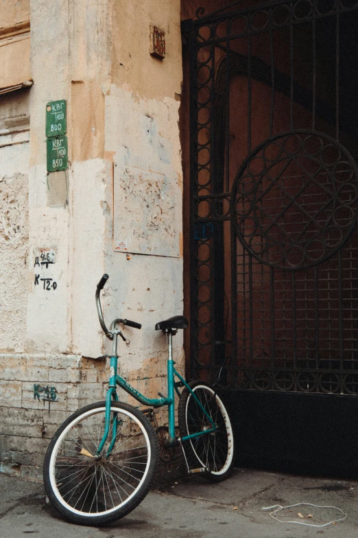 a blue bicycle is leaning against a building on the street