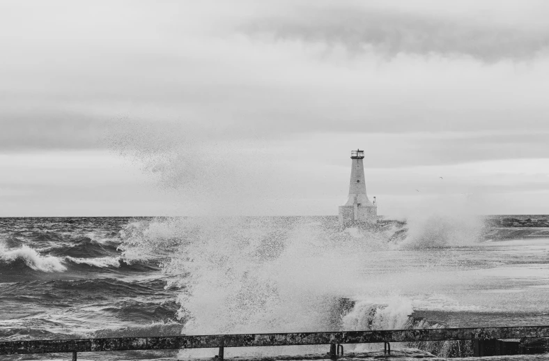 the waves are approaching the lighthouse on the beach